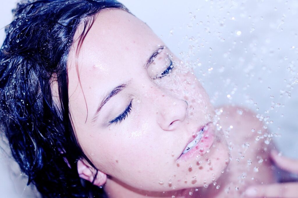 vrouw krijgt douche stralen op gezicht